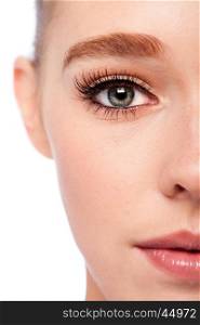 Beautiful eye with eyebrow and lashes on half face of attractive young woman.