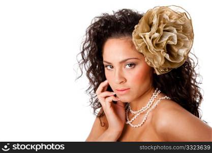 Beautiful face of a Caucasian Hispanic woman with clear skin, wearing a pearl necklace and a fake flower in curly hair, isolated.