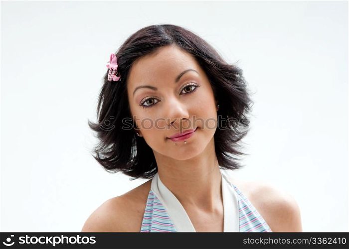 Beautiful face of a Latina woman with black hair and pink ribbon and lip piercings, isolated