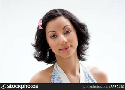 Beautiful face of a Latina woman with black hair and pink ribbon and lip piercings, isolated