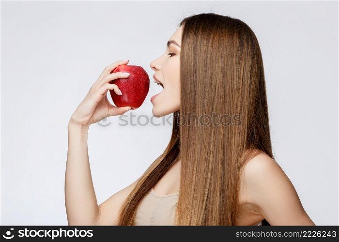 Beautiful Face of Young Woman with Clean Fresh Skin close up. Beauty Portrait. Beautiful Spa Woman Smiling. Perfect Fresh Skin. Pure Beauty Model. Youth and Skin Care Concept. Beautiful Woman with Clean Fresh Skin holding apple