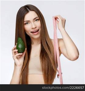 Beautiful Face of Young Woman with Clean Fresh Skin close up. Beauty Portrait. Beautiful Spa Woman Smiling. Perfect Fresh Skin. Pure Beauty Model. Youth and Skin Care Concept. Beautiful Woman with Clean Fresh Skin holding avocado