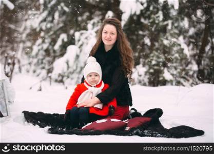 Beautiful family of mother and her little daughter enjoying snowy winter day in forest.. Beautiful family of mother and her little daughter enjoying snowy winter day in forest