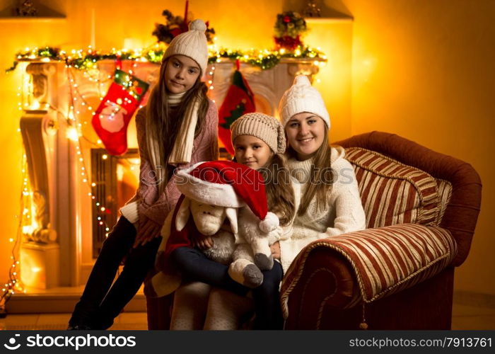 Beautiful family portrait against fireplace at Christmas eve at house