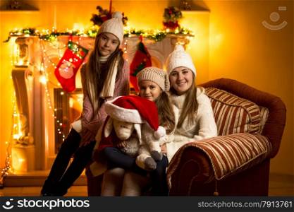Beautiful family portrait against fireplace at Christmas eve at house