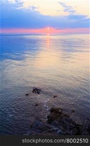 Beautiful fascinate morning sea view with sunrise, sun track on surface and fishing nets.