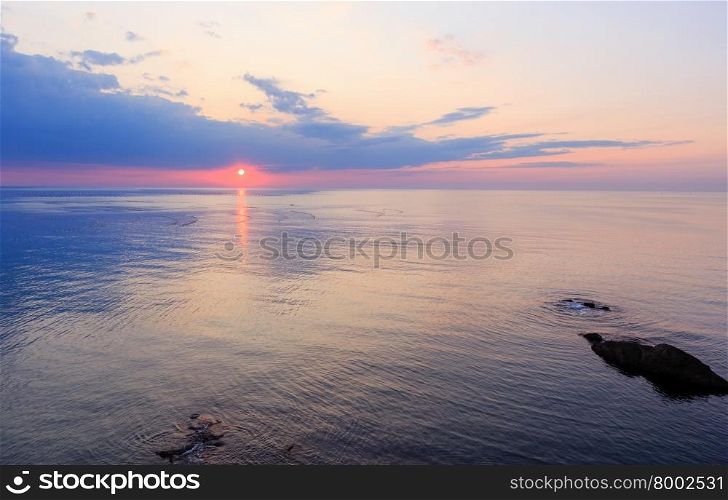 Beautiful fascinate morning sea view with sunrise, sun track on surface and fishing nets.