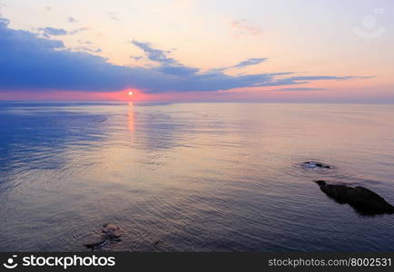 Beautiful fascinate morning sea view with sunrise, sun track on surface and fishing nets.