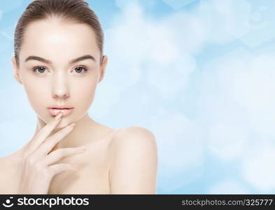 Beautiful fashion model girl natural makeup spa skin care portrait on blue bokeh background