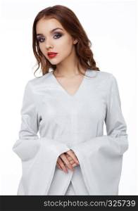 Beautiful fashion model wearing silver dress with long sleeves on white background
