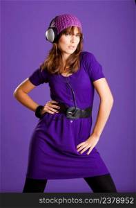 Beautiful fashion young woman listen music with headphones, over a violet background