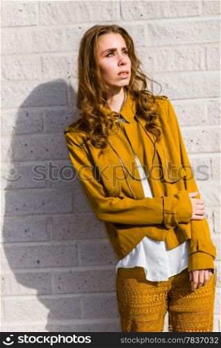 Beautiful fashionable woman in front of a white brick wall