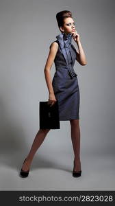 Beautiful fashionable young woman in stylish dress posing. Studio shot