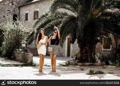Beautiful fashionable young women posing on the street in summer