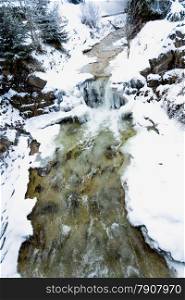 Beautiful fast mountain river in Austrian Alps at winter