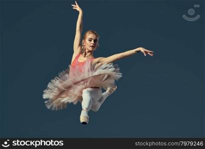 Beautiful female ballet dancer on a grey background. . Beautiful female ballet dancer on a grey background. Ballerina is wearing pink tutu and pointe shoes