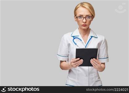 beautiful female doctor holding tablet pc pad isolated on grey background,. beautiful female doctor holding tablet pc pad isolated on grey background