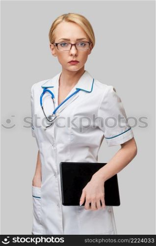 beautiful female doctor holding tablet pc pad isolated on grey background,. beautiful female doctor holding tablet pc pad isolated on grey background