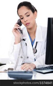 Beautiful female doctor trying the phone very seriously on isolated white background