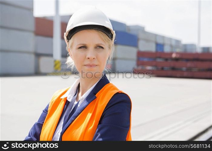 Beautiful female engineer looking away in shipping yard