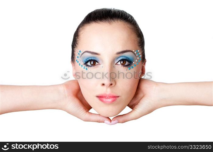 Beautiful female fashion face with blue makeup and gems rhinestones of a Caucasian Hispanic woman held with hands in the air, isolated.