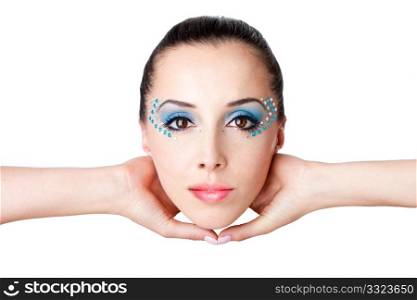 Beautiful female fashion face with blue makeup and gems rhinestones of a Caucasian Hispanic woman held with hands in the air, isolated.