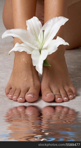 beautiful female feet with madonna lily in spa