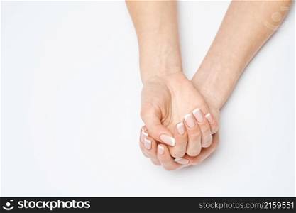Beautiful Female Hands with French manicure over light grey background.. Beautiful Female Hands with French manicure over light grey background