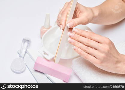 Beautiful Female Hands with French manicure over light grey background.. Beautiful Female Hands with French manicure over light grey background