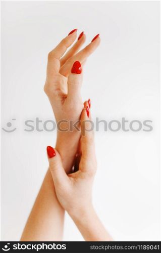 Beautiful female hands with red manicure isolated on white background. Beauty salon, professional service. Female customer hands after fingernail care procedure in spa studio