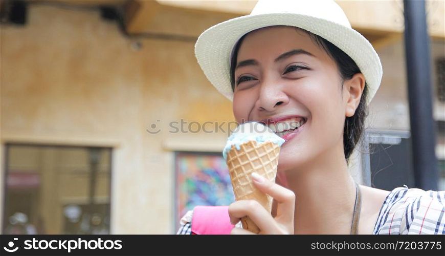 Beautiful female holding and eating ice cream on summer holidays