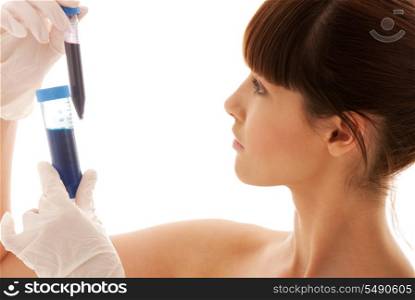 beautiful female lab worker holding up test tubes