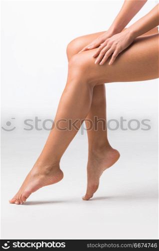 Beautiful female legs. Beautiful female legs touched by hand on white background
