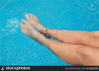 Beautiful female legs in the pool water