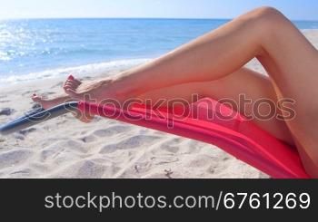 Beautiful female legs on a beach lounger