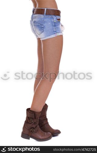 Beautiful female legs, part of the body. Blue short denim shorts and brown boots, isolated on white background