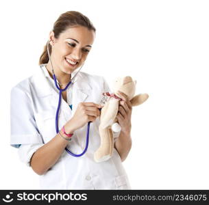 Beautiful female nurse taking care of a teddy bear with stethoscope
