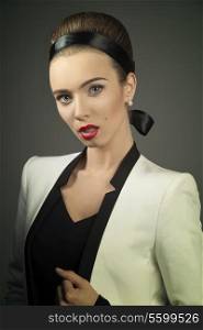 beautiful female posing with elegant clothes, hair-style and make-up in fashion portrait. Wearing white jacket and black dress