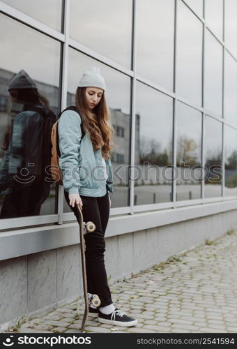 beautiful female skater holding her skateboard 2