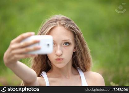 Beautiful Female Teenager Making Face a Selfie with Phone