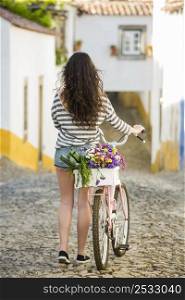 Beautiful female tourist living like a local, with her bicycle after buying some fresh vegetables