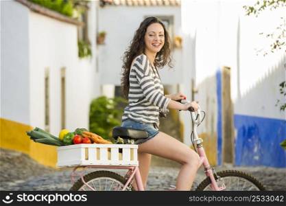 Beautiful female tourist living like a local, with her bicycle after buying some fresh vegetables