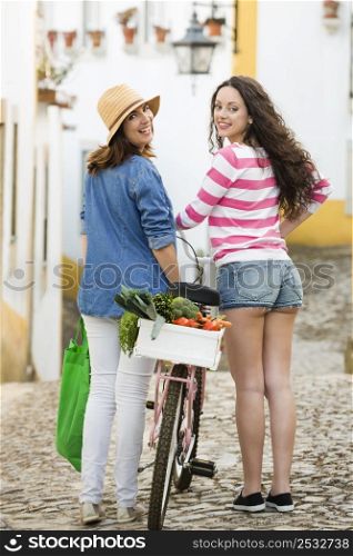 Beautiful female tourists walking together in a typical village