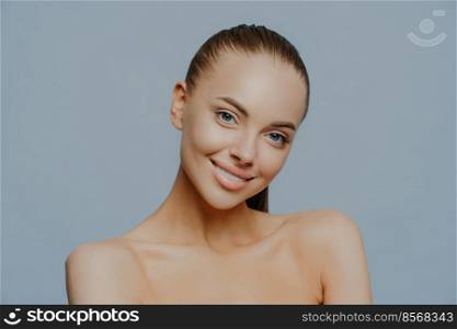 Beautiful feminine woman gazes sensual and relaxed, takes care of beauty and skin, tilts head and stands bare shoulders, feels great after making spa procedures. Tennderness and cosmetology.