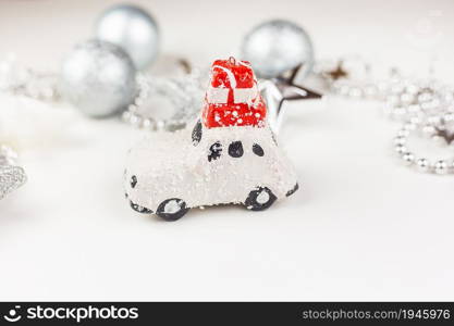 Beautiful festive decor in gray tones, a small car with gifts on the roof in the center of the frame. New Year&rsquo;s mood. Beautiful festive decor in gray tones, a small car with gifts on the roof in the center of the frame. New Year&rsquo;s mood.