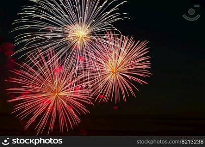 Beautiful festive fireworks in the sky for a holiday. Bright multi-colored salute on a black background. Place for text.. Festive fireworks in the sky for a holiday. Bright multi-colored salute on a black background. Place for text.