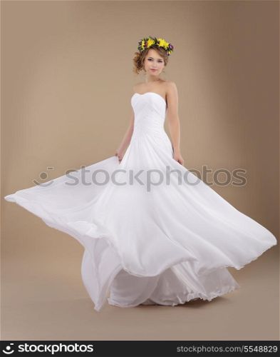 Beautiful Fiancee with Vernal Wreath of Flowers in Flying Wedding Dress