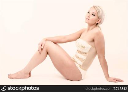 Beautiful fitness girl wearing swimsuit, she is sitting, horizon image