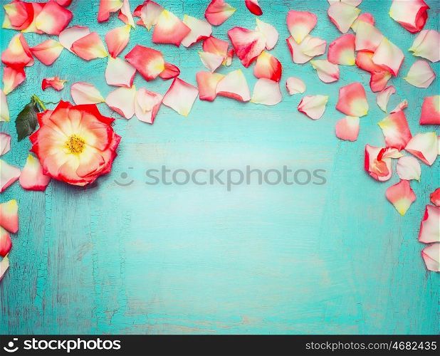Beautiful floral border with petals on turquoise blue background, top view, place fot text