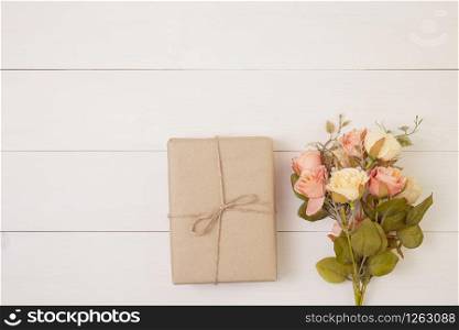 Beautiful flower and gift box on wooden background with romantic, presents for mother day or valentine day with pastel tone, spring or summer nature for decoration on desk, holiday concept.
